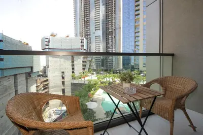 a balcony with a table and chairs and a view of a city at Luxury Studio in Aykon Tower - Pool & Gym Access in Dubai