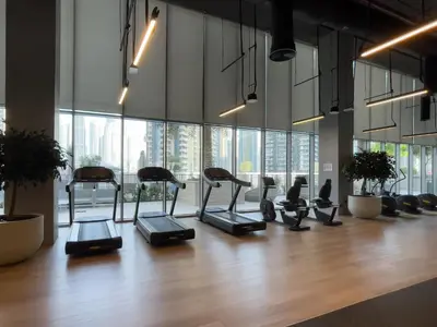 a gym with cardio equipment in a room with large windows at Exotic 2 bed downtown Burj Khalifa dist Dubai mall in Dubai