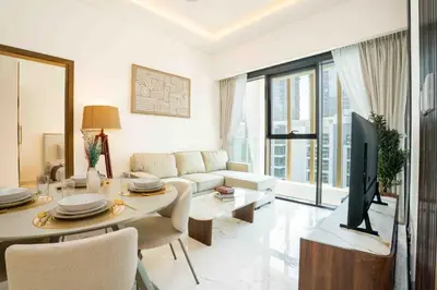 a living room with a couch and a table with a tv at Escape24 Stylish 2BR with Pool View at Azizi Riviera in Dubai