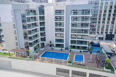 an aerial view of a building with a swimming pool at Escape24 Stylish 2BR with Pool View at Azizi Riviera in Dubai