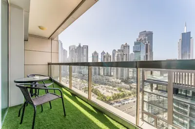 a balcony with a table and chairs and a view of the city at 1BR Near Burj Khalifa and Dubai Mall, Easy Access to Dubai Marina and Palm Jumeirah by Road or Metro, BLVD Walk, Downtown Dubai by Deluxe Holiday Homes in Dubai