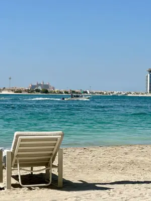 a beach chair sitting on the sand on the beach at OceanView 1bed apartment with Private Beach in Dubai