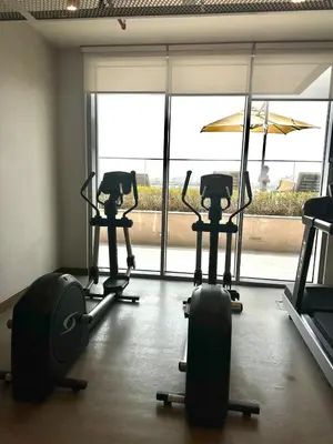 a gym with three exercise bikes and an umbrella at OceanView 1bed apartment with Private Beach in Dubai