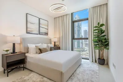 a bedroom with a white bed and a large window at Downtown Luxury 2 Bed Apartment in Dubai