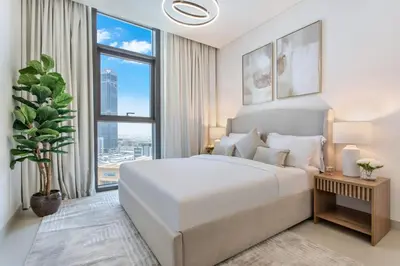 a bedroom with a large white bed and a large window at Downtown Luxury 2 Bed Apartment in Dubai
