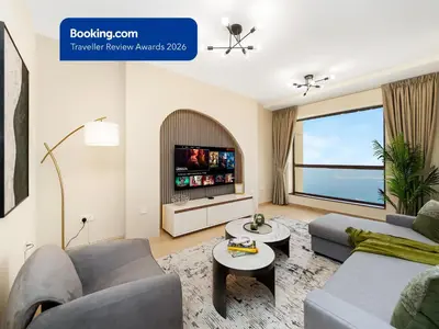 a living room with a couch and a tv at JBR's Luxury 2BDR with Dubai Eye, Palm & Marina Views - Direct Beach Access in Dubai