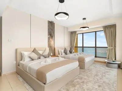 a bedroom with two beds and a large window at JBR's Luxury 2BDR with Dubai Eye, Palm & Marina Views - Direct Beach Access in Dubai