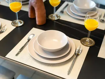 a table with plates and glasses of orange juice at JBR's Luxury 2BDR with Dubai Eye, Palm & Marina Views - Direct Beach Access in Dubai