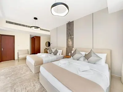 two beds in a large room with white walls at JBR's Luxury 2BDR with Dubai Eye, Palm & Marina Views - Direct Beach Access in Dubai