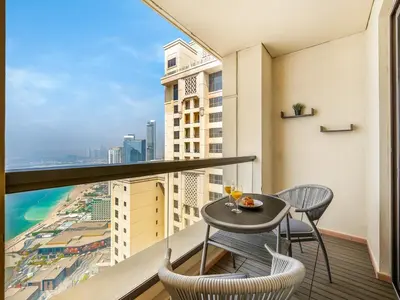 a balcony with a table and chairs and a view at JBR's Luxury 2BDR with Dubai Eye, Palm & Marina Views - Direct Beach Access in Dubai