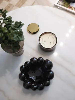 a clock and a potted plant on a table at JVC - Designer 2 BHK apartment - Pool&Gym - by MKB LIVING in Dubai