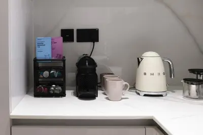 a counter with a coffee maker and cups on it at JVC - Designer 2 BHK apartment - Pool&Gym - by MKB LIVING in Dubai