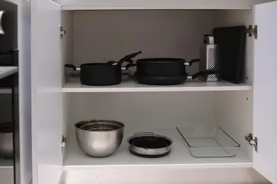 three pots and pans on a shelf in a kitchen at JVC - Designer 2 BHK apartment - Pool&Gym - by MKB LIVING in Dubai