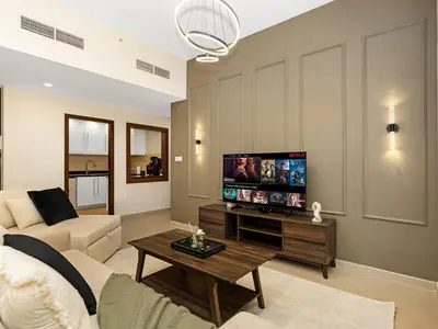 a living room with a couch and a tv at Jumeirah Beachfront with Ain View and Sea View 2BR in Dubai