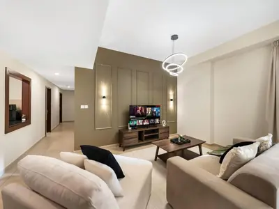 a living room with two couches and a tv at Jumeirah Beachfront with Ain View and Sea View 2BR in Dubai