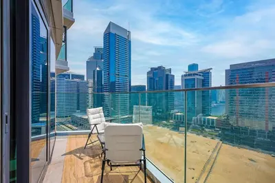 a balcony with two chairs and a view of the city at Modern Sophistication with Stunning City Views in Dubai