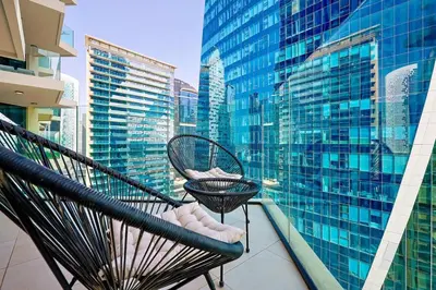 a balcony with two chairs and a view of a city at Luxury Studio Retreat Canal View and City Life in Dubai