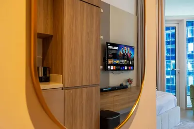 a room with a tv and a living room at Luxury Studio Retreat Canal View and City Life in Dubai