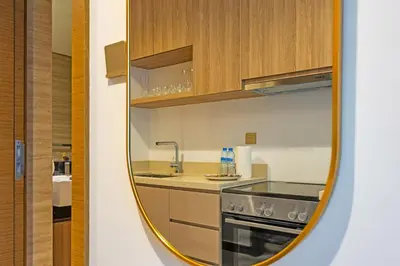 a small kitchen with a sink and a mirror at Luxury Studio Retreat Canal View and City Life in Dubai