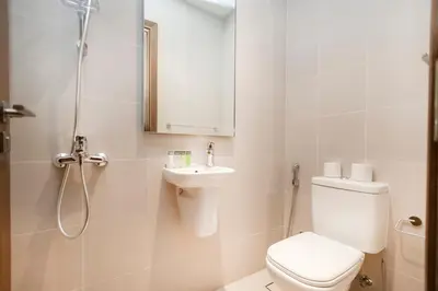 a bathroom with a toilet and a sink and a shower at Cozy 2BR APT With Canal Views, Pool with Burj View in Dubai