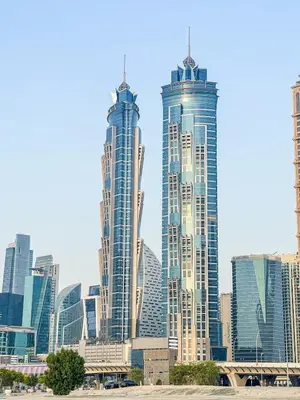two tall skyscrapers in a large city with buildings at Cozy 2BR APT With Canal Views, Pool with Burj View in Dubai