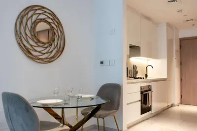 a dining room with a glass table and chairs at TRPS - Marquise Square, Business Bay - Burj Khalifa View, Spacious Studio, Fully Furnished in Dubai