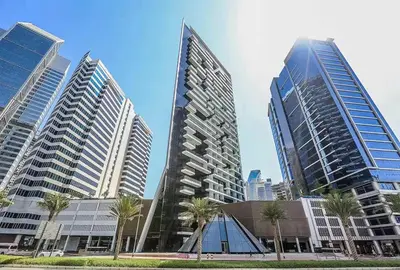 a group of tall buildings in a city with palm trees at TRPS - Marquise Square, Business Bay - Burj Khalifa View, Spacious Studio, Fully Furnished in Dubai