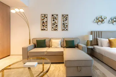 a living room with a couch and a glass table at TRPS - Marquise Square, Business Bay - Burj Khalifa View, Spacious Studio, Fully Furnished in Dubai