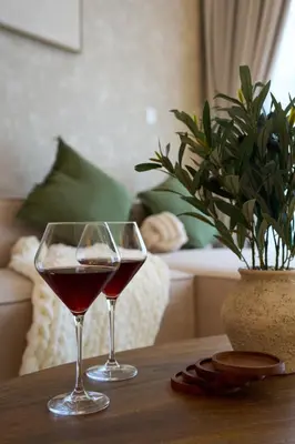 two glasses of wine sitting on a wooden table at Luxury 1BR Apt Dowtown Dubai Imperial Avenue with Burj Khalifa Views in Dubai