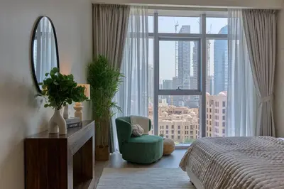 a bedroom with a large window with a chair and a mirror at Luxury 1BR Apt Dowtown Dubai Imperial Avenue with Burj Khalifa Views in Dubai