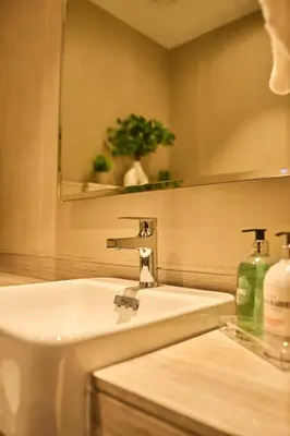 a bathroom sink with a mirror and a bottle of soap at Luxury 1BR Apt Dowtown Dubai Imperial Avenue with Burj Khalifa Views in Dubai