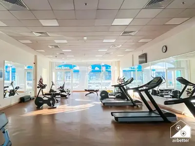 a gym with treadmills and elliptical machines at Elegant Studio with Balcony & Full Amenities in Dubai