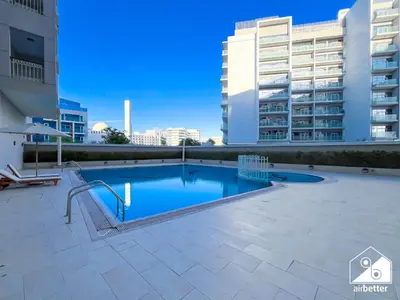 a swimming pool in the middle of a building at Elegant Studio with Balcony & Full Amenities in Dubai