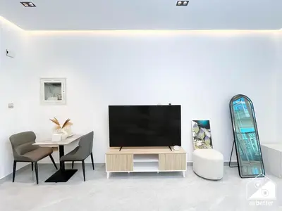 a living room with a television and a table and chairs at Elegant Studio with Balcony & Full Amenities in Dubai
