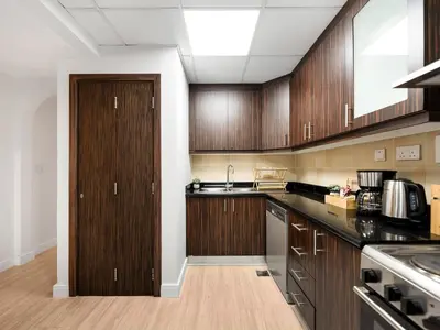 a kitchen with wooden cabinets and a sink at JBR Beachfront with Full Sea and Ain Dubai View in Dubai
