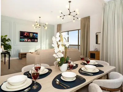 a dining room with a table with plates and wine glasses at JBR Beachfront with Full Sea and Ain Dubai View in Dubai