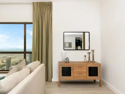 a living room with a couch and a mirror at JBR Beachfront with Full Sea and Ain Dubai View in Dubai