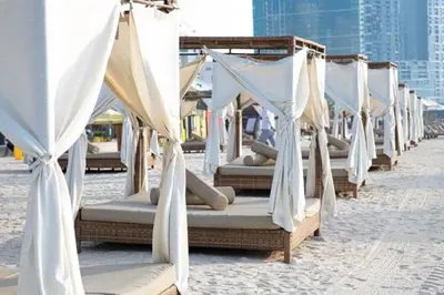a row of beds on a beach with curtains at JBR Dubai VIP Lux Penthouse priv Pool cinema Limo tranfer-housekeeper in Dubai