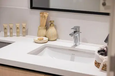 a bathroom sink with a faucet and vases at Mahogany 18 - 2BR 10 Guests - Walk to Dubai Mall in Dubai