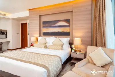 a hotel room with a bed and a chair at Suitestay-Fahion Avenue Dubai mall in Dubai
