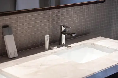 a bathroom with a sink and a faucet at Skyline Aura 1 & 2 Bedroom Apartments I Burj Khalifa & Fountain Views I Dubai Mall Access I Parking, Gym, Wi-Fi & Infinity Pool in Dubai