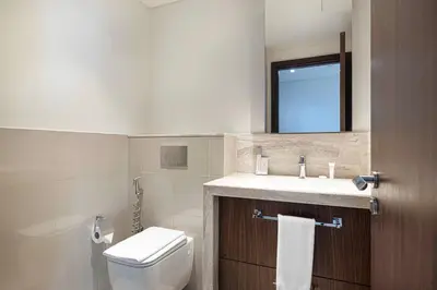 a bathroom with a toilet and a sink and a mirror at Skyline Aura 1 & 2 Bedroom Apartments I Burj Khalifa & Fountain Views I Dubai Mall Access I Parking, Gym, Wi-Fi & Infinity Pool in Dubai