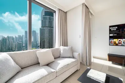 a living room with a couch and a large window at Skyline Aura 1 & 2 Bedroom Apartments I Burj Khalifa & Fountain Views I Dubai Mall Access I Parking, Gym, Wi-Fi & Infinity Pool in Dubai