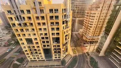 an aerial view of a tall yellow apartment building at Limelight Partiton Room In Tecom Barsha Heights Near ICM Metro in Dubai