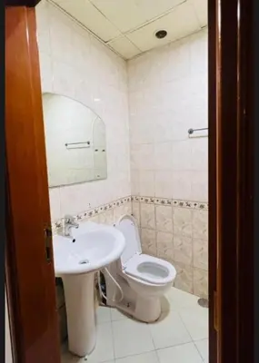 a bathroom with a sink and a toilet and a mirror at The Cozy Classic Room In Barsha Heights ICM Metro in Dubai