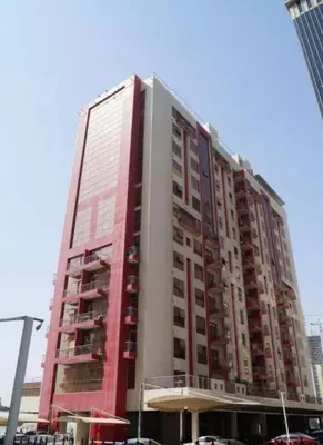 a tall building with cars parked in front of it at The White Haven Room in Tecom Barsha Heights in Dubai