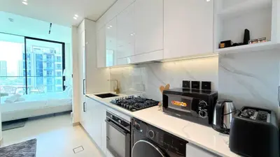 a kitchen with a stove top oven next to a sink at Premium Studio In Jvc Bazr in Dubai