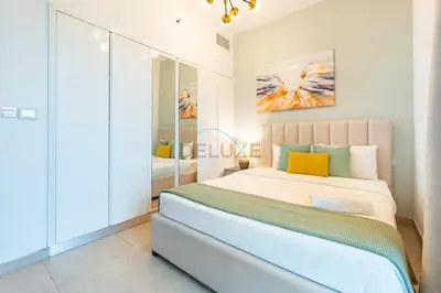 a bedroom with a large bed in a room at Balcony Overlooking the Community, Quick Metro Access,Short 15-Minute Drive to Ibn Battuta Mall, Viktoria Residency, Al Furjan by Deluxe Holiday Homes in Dubai