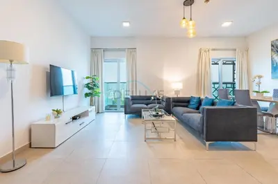 a living room with a couch and a tv at Balcony Overlooking the Community, Quick Metro Access,Short 15-Minute Drive to Ibn Battuta Mall, Viktoria Residency, Al Furjan by Deluxe Holiday Homes in Dubai