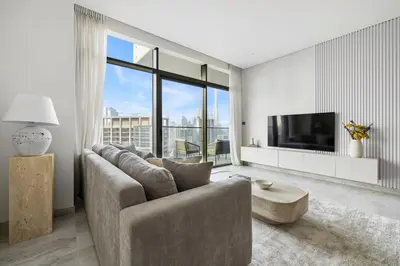 a living room with a couch and a tv at 1BR with Direct Burj Khalifa View in Dubai